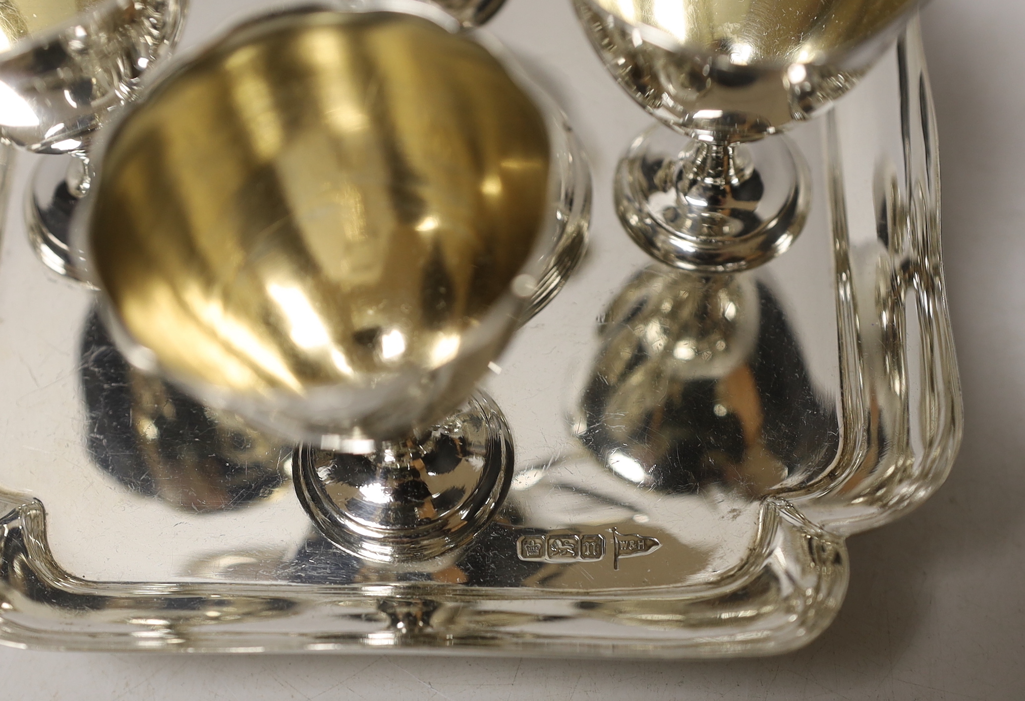 An Edwardian silver egg cruet, with loop handle and four cups, Walker & Hall, Sheffield, 1905/6, height 19.3cm, 17.2oz.